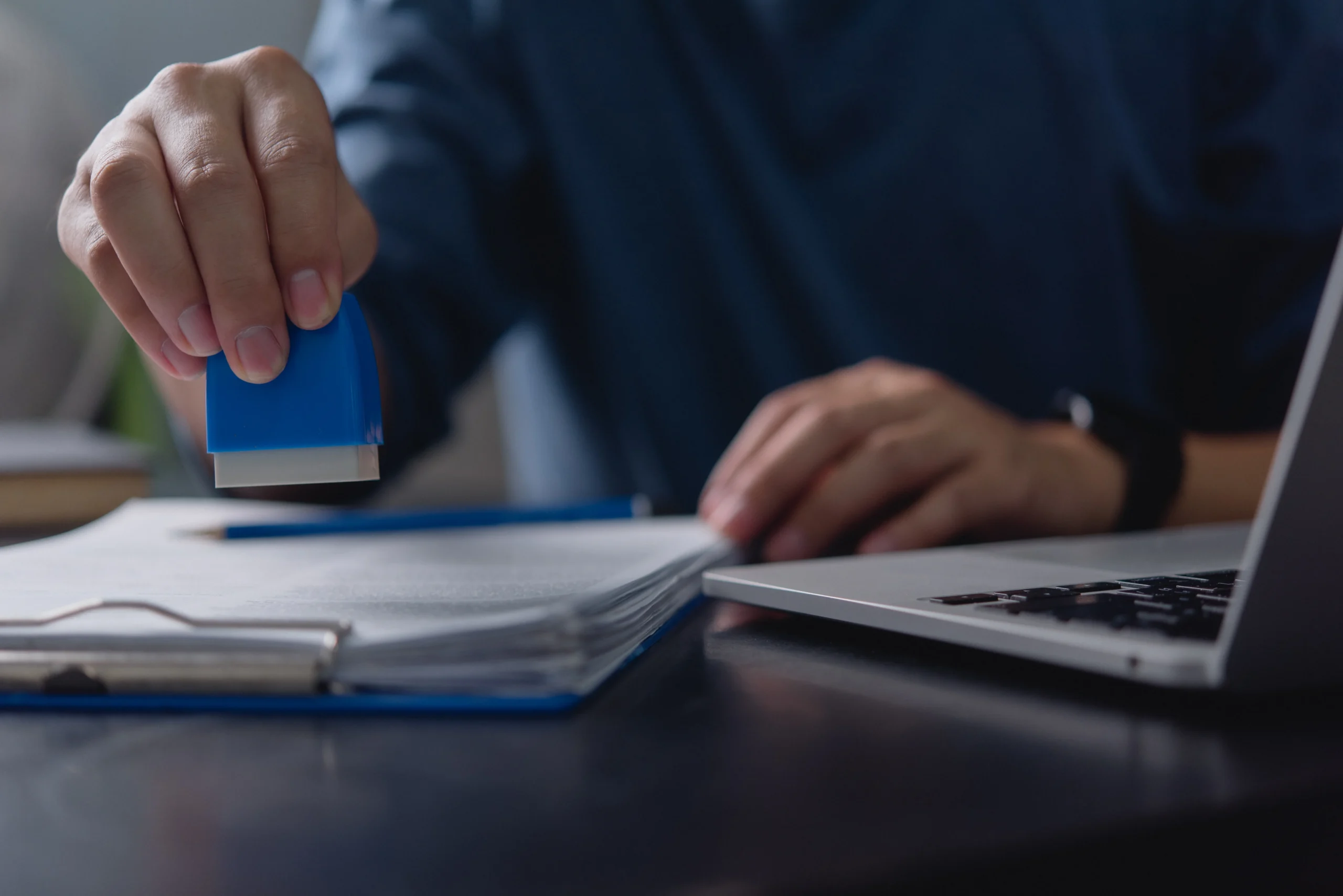 Business administration, office employee stamping paperwork, official document processing, contract approval system, business compliance, certification process, document verification.