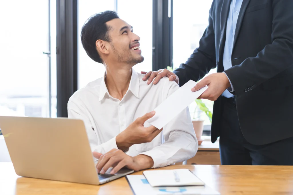 Good job Asian manager business man giving financial reward in an envelope, business letter extra salary to company employee, male worker office hand received premium bonus, getting cheque from boss.